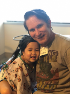 Dad with smiling but sick daughter