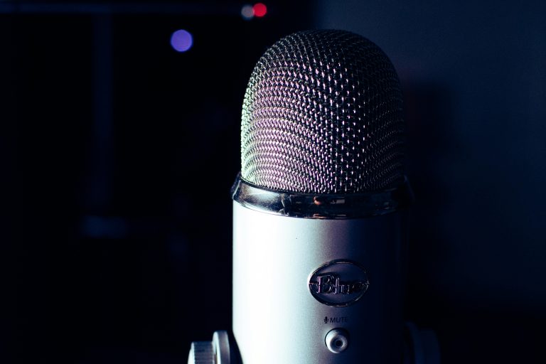 Dynamic photo of a condenser microphone in a dimly lit studio, perfect for podcasts.