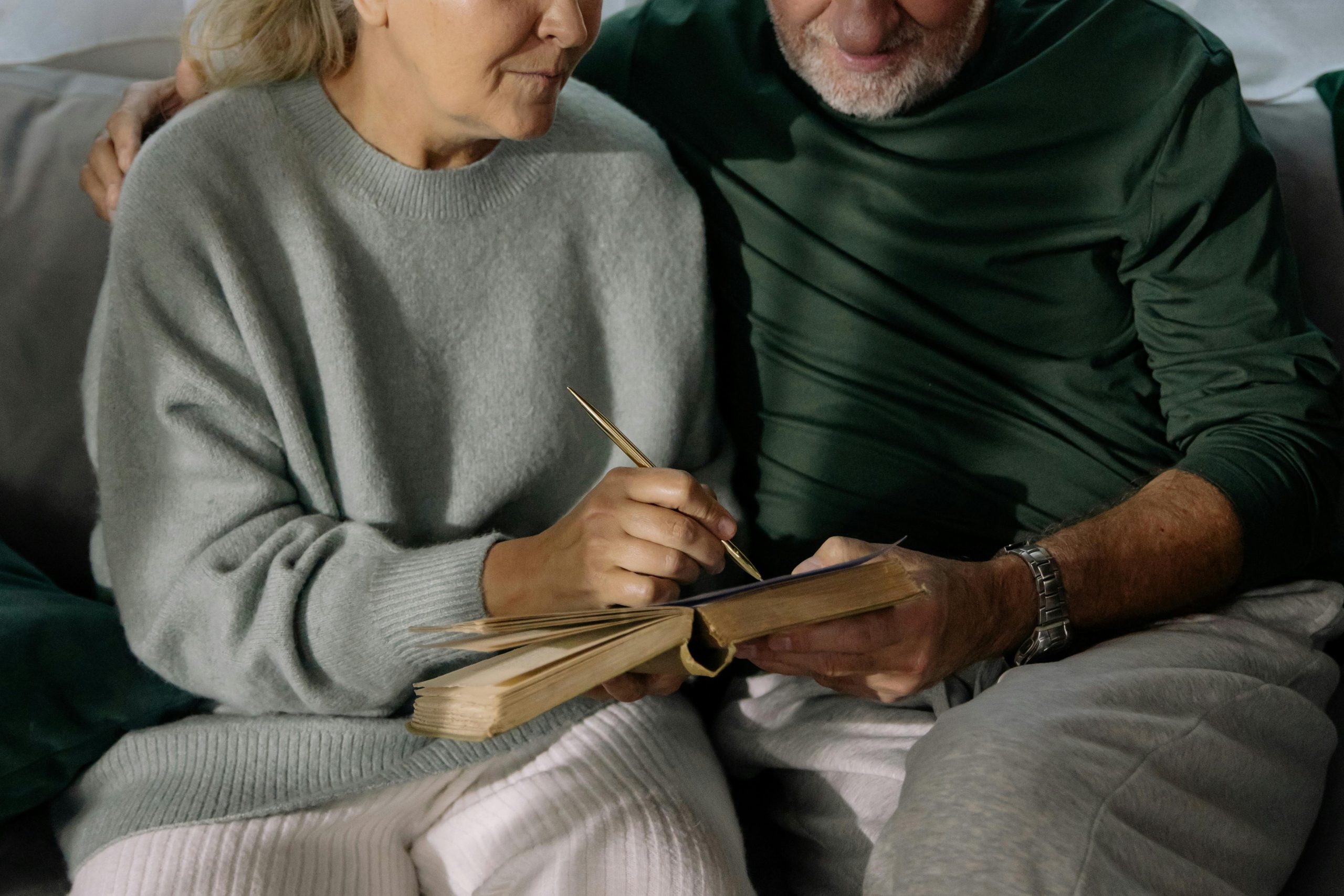 Elderly couple writing together in a cozy living room, sharing memories and affection.